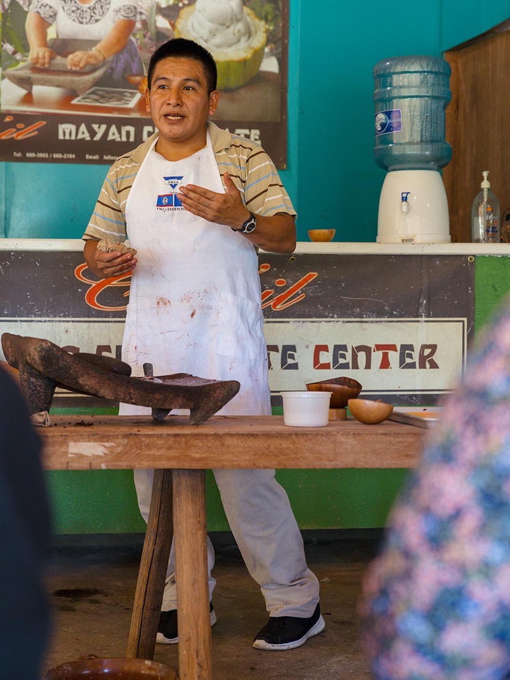 A man stands in front of an audience teaching them about how chocolate is made from the cacao bean.