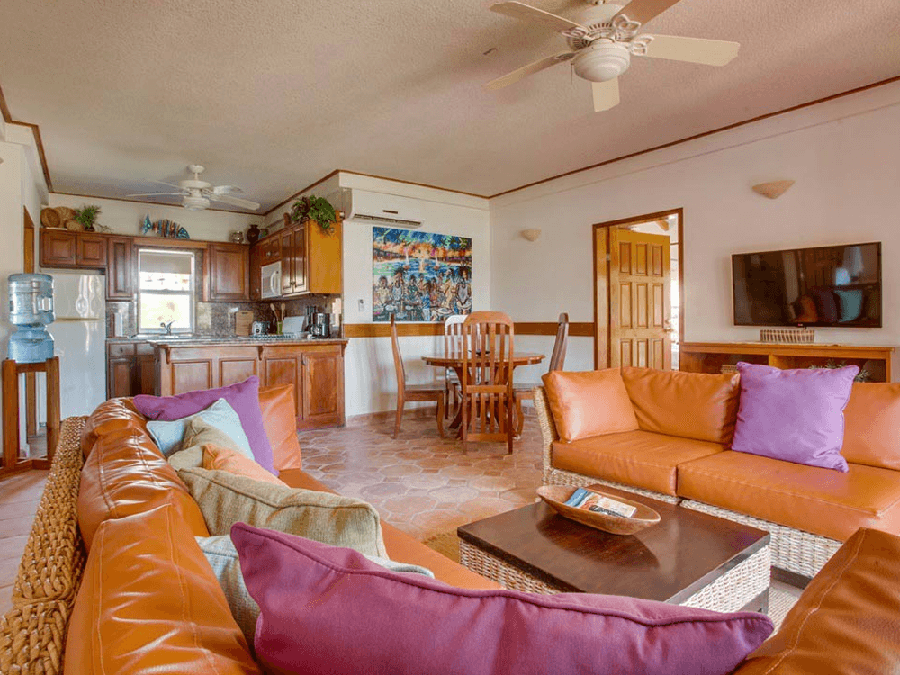 View of living dining and kitchen, pine color furniture, tile floors and tropical couches