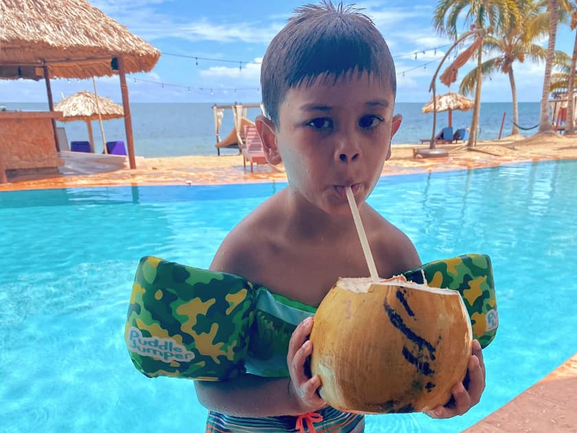 Child enjoying a cool beverage by the pool at Belizean Dreams