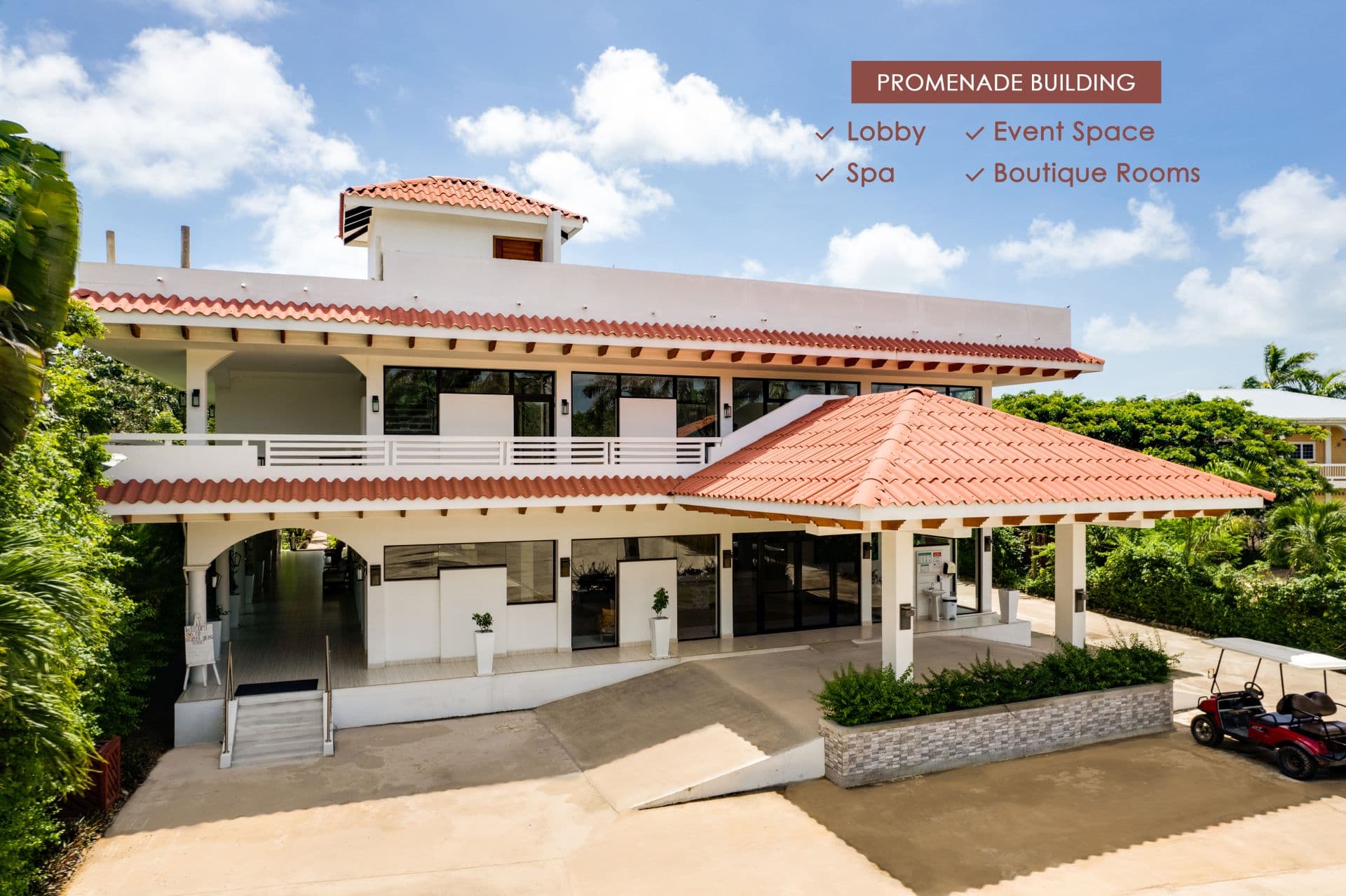 The building is a two-story structure with a red tile roof and a large entranceway. The building houses boutique rooms.